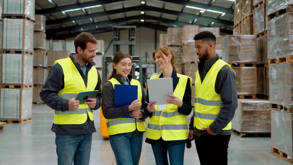 Full team of warehouse employees standing in warehouse. Team of workers in reflective clothing in modern industrial factory, heavy industry, manufactrury. Group video.