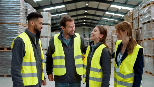 Full team of warehouse employees standing in warehouse. Team of workers in reflective clothing in modern industrial factory, heavy industry, manufactrury. Group video.