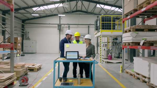 Female engineer, foreman consulting with director in modern industrial factory, talking about new production project, investment. Team management in manufacturing facility.