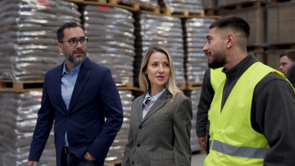 Engineers consulting with director in modern industrial factory, talking about new production project, investment. Team management in manufacturing facility.