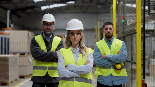 A video of team of warehouse employees standing in warehouse. Team of worker and managers in modern industrial factory, heavy industry, manufactrury. Concept of team management.