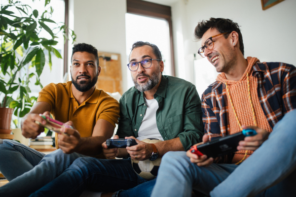 Best friends playing together on video game console, competing. Concept of male friendship, bromance.