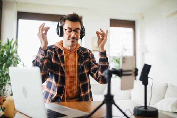 Man as mental health influencer making video for social media. Influencer, doing telepsychology, creating online content about mental health, mental well-being, teaching breath exercises.