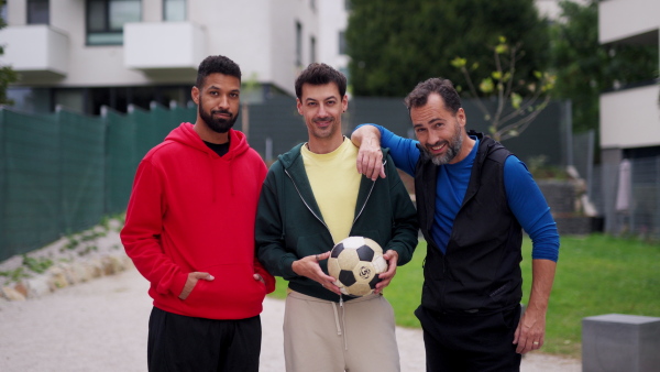 Best friends playing sport outdoors, having fun, competing. Playing football at a local pitch, enjoying exercise together. Concept of male friendship, bromance.