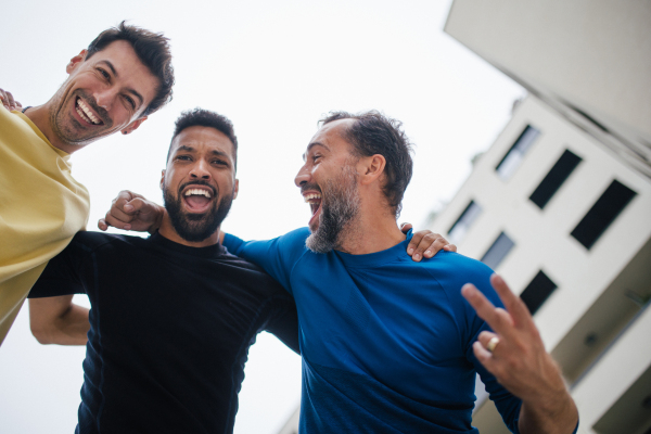 Best friends playing sport outdoors, having fun, competing. Playing basketball at local court, enjoying exercise together. Concept of male friendship, bromance.