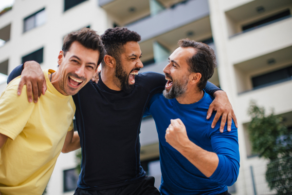 Best friends playing sport outdoors, having fun, competing. Playing basketball at local court, enjoying exercise together. Concept of male friendship, bromance.