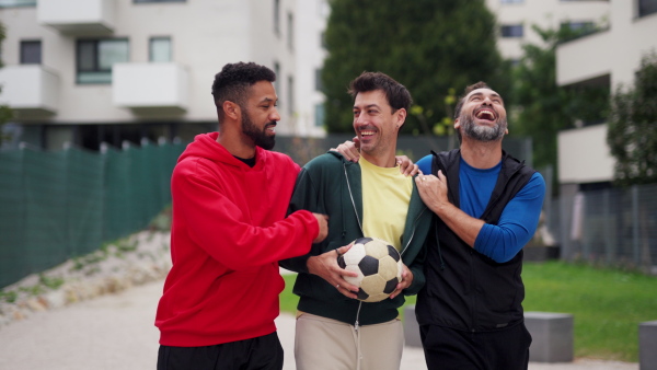 Best friends playing sport outdoors, having fun, competing. Playing football at a local pitch, enjoying exercise together. Concept of male friendship, bromance.