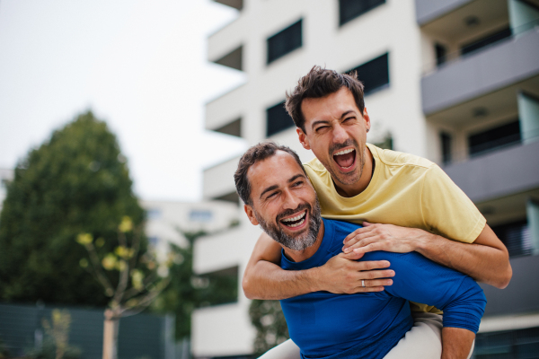 Best friends playing sport outdoors, having fun. Celebratin goal, carrying friend on back, piggybacking. Concept of male friendship, bromance.