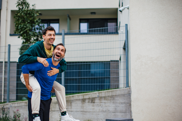 Best friends playing sport outdoors, having fun. Celebratin goal, carrying friend on back, piggybacking. Concept of male friendship, bromance.