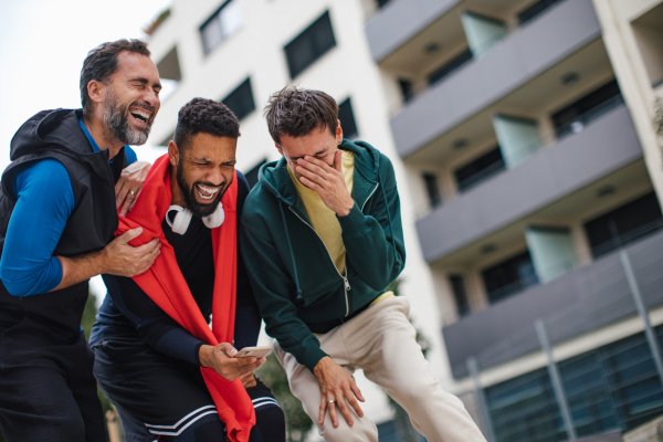 Best friends playing sport outdoors, having fun, competing. Playing basketball at local court, enjoying exercise together. Concept of male friendship, bromance.