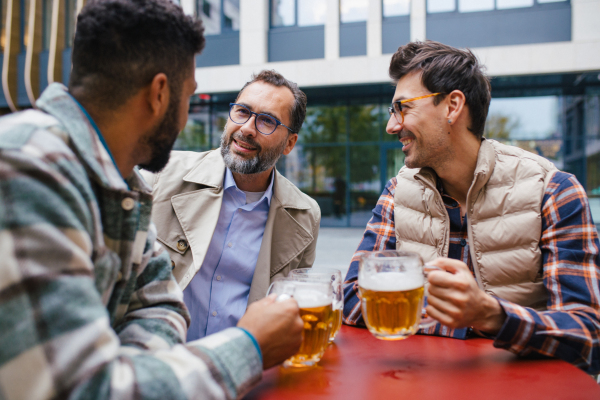 Best friends togehter, drinking beer in bar in the city and talking, having fun and laugh. Concept of male friendship, bromance.