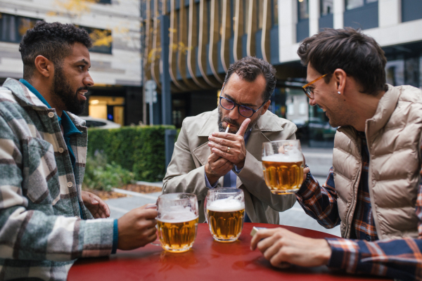 Best friends togehter, drinking beer in bar in the city and talking, having fun and laugh. Concept of male friendship, bromance.