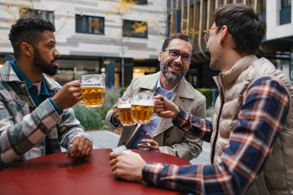 Best friends togehter, drinking beer in bar in the city and talking, having fun and laugh. Concept of male friendship, bromance.