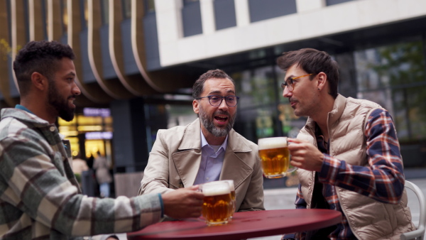 Best friends togehter, drinking beer in bar in the city and talking, having fun and laugh. Concept of male friendship, bromance.