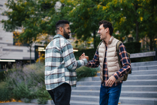 Best friends meeting outdoors, happy to see each other, man's hug. Concept of male friendship, bromance.