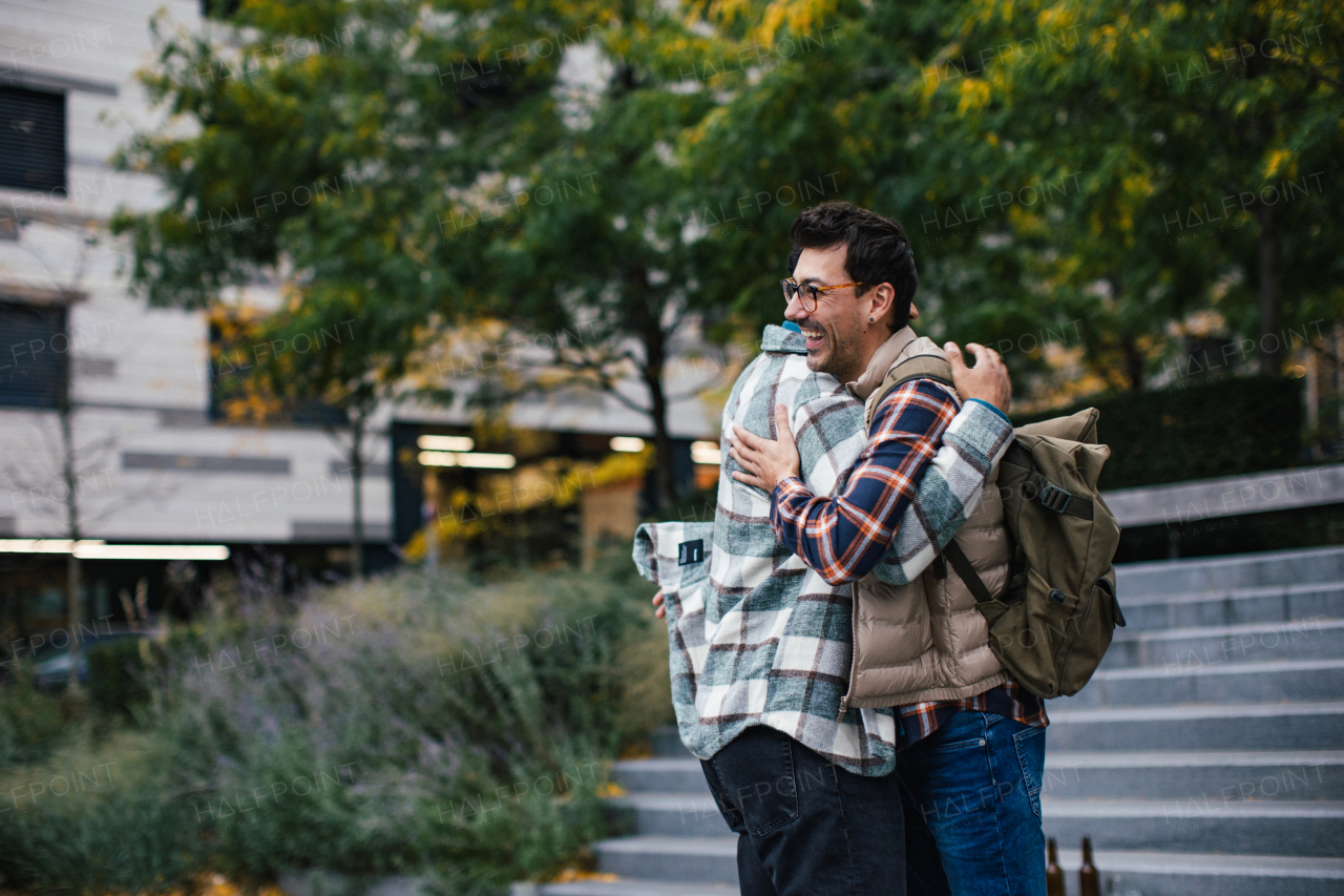 Best friends meeting outdoors, happy to see each other, man's hug. Concept of male friendship, bromance.