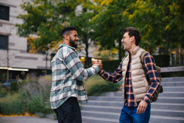 Best friends meeting outdoors, happy to see each other, man's hug. Concept of male friendship, bromance.