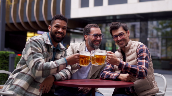 Best friends togehter, drinking beer in bar in the city and talking, having fun and laugh. Concept of male friendship, bromance.