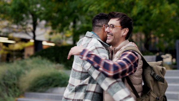 Best friends meeting outdoors, happy to see each other, man's hug. Concept of male friendship, bromance.