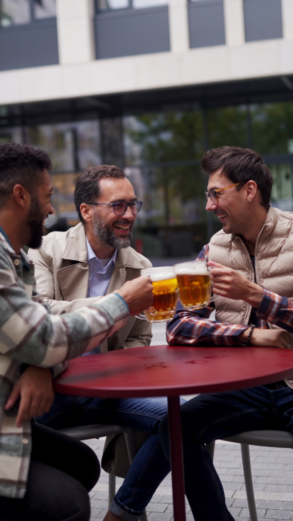 Best friends togehter, drinking beer in bar in the city and talking, having fun and laugh. Concept of male friendship, bromance.