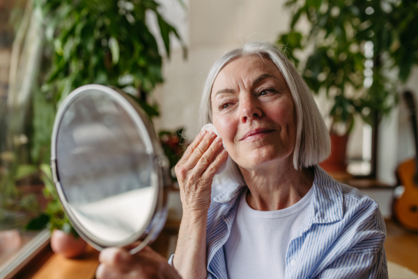 Portrait of beautiful mature woman with gray hair and soft smile, looking at camera.