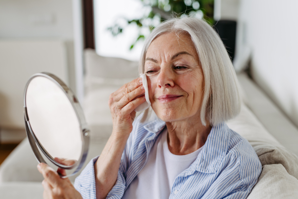 Portrait of beautiful mature woman with gray hair and soft smile, looking at camera.