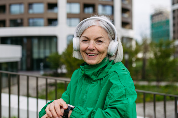 MaturMature woman checking her performance on smartwatche after run. Exercising after work for good mental health, physical health, and relieving stress and boost mood.