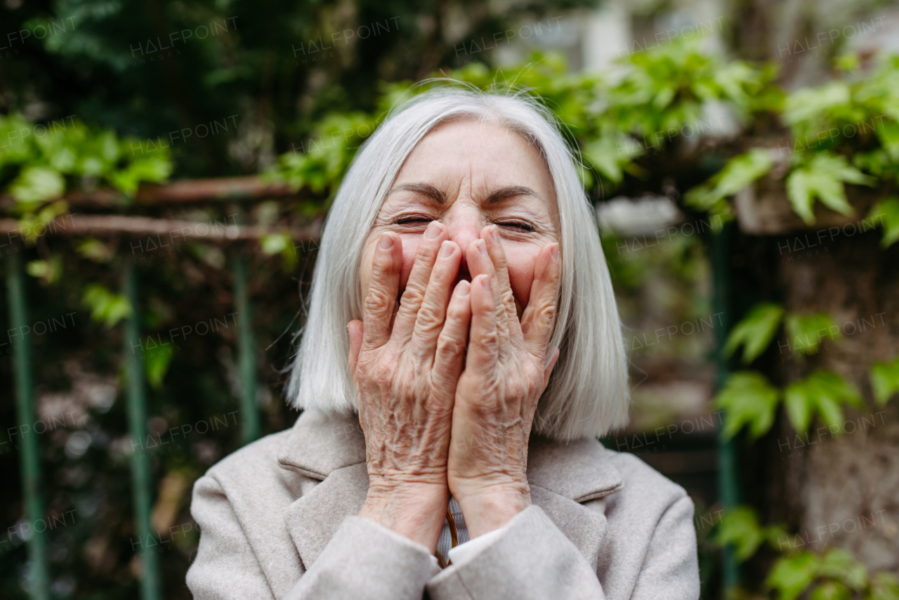 Portrait of stylish mature woman blowing a kiss.Beautiful older woman with gray hair outdoors.