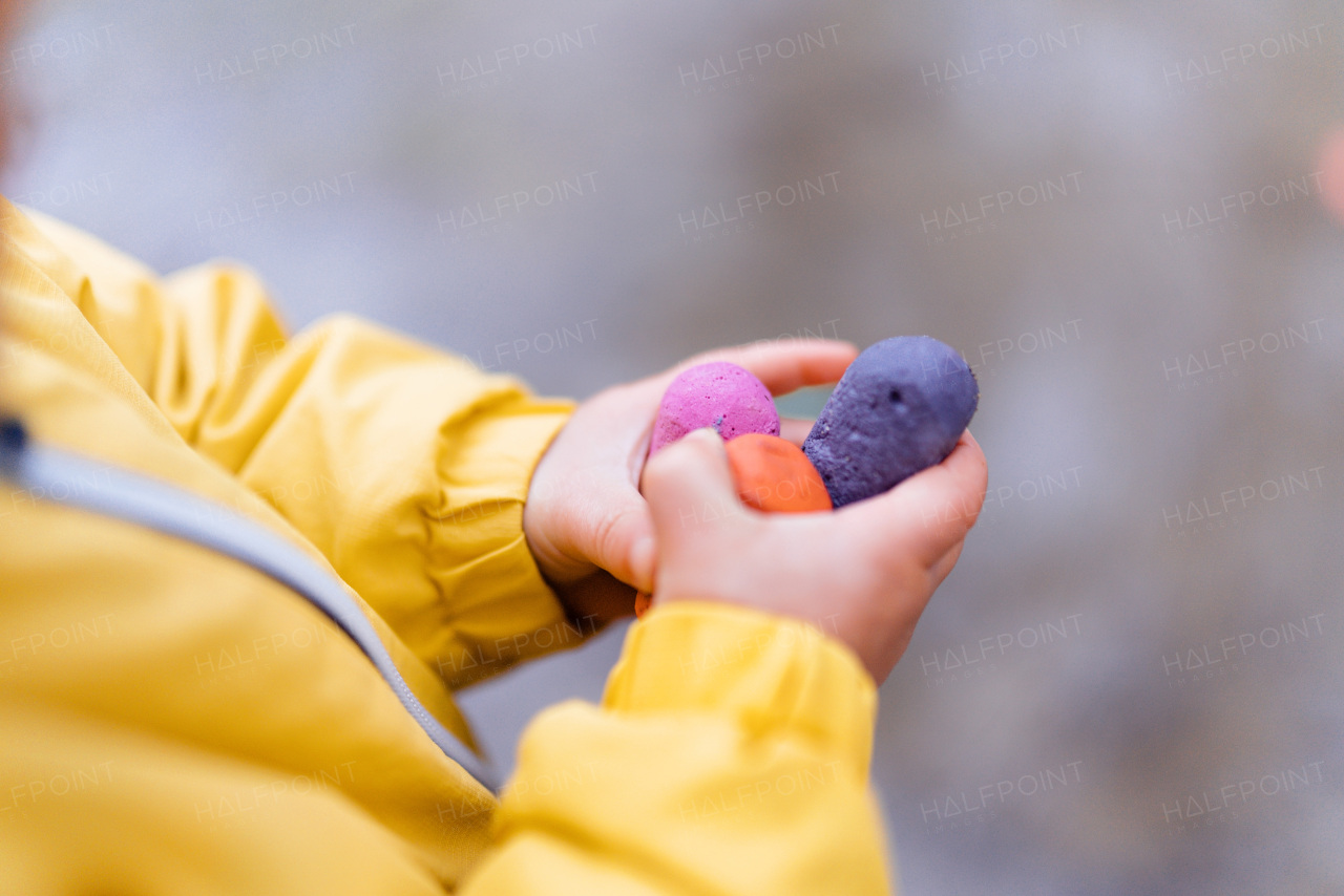 Close-up of little child holding colourful chalks.