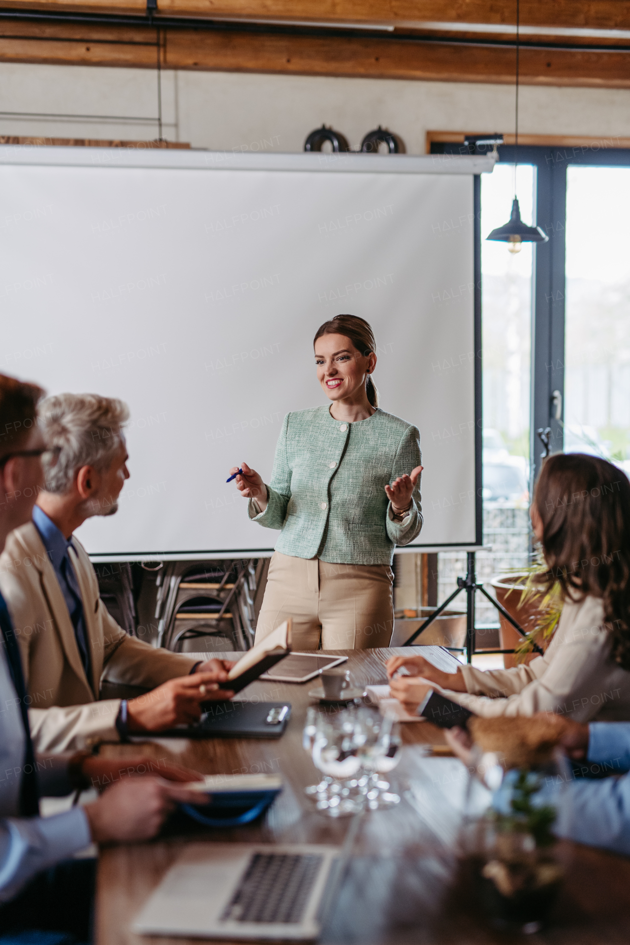 Female CEO manager leading corporate meeting in office. Businesswoman in meeting with colleagues in conference room.