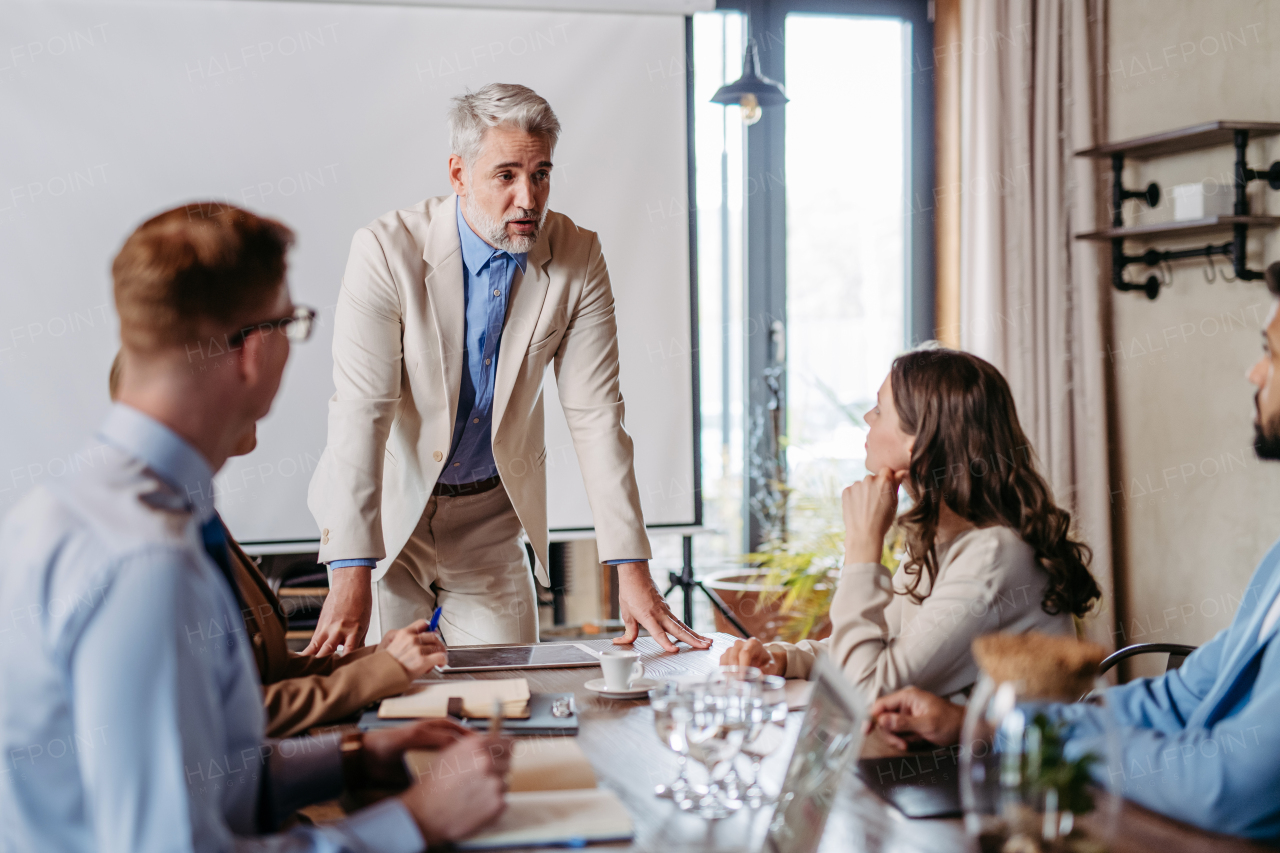 Businessman giving a presentation in a business meeting. Young colleagues and manager having casual discussion during meeting, workshop in office.