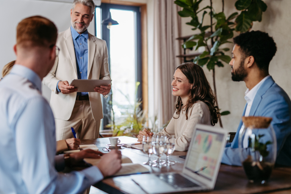 Businessman giving a presentation in a business meeting. Young colleagues and manager having casual discussion during meeting, workshop in office.