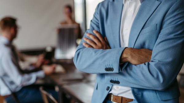 Close up of businessman with crossed arms during meeting.