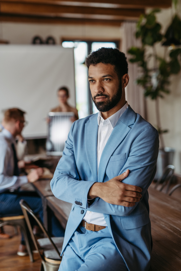 Portrait of confident young businessman during team meeting. Young colleagues discussing photovoltaic panels, clean, green, energy. Business using renewable energy.