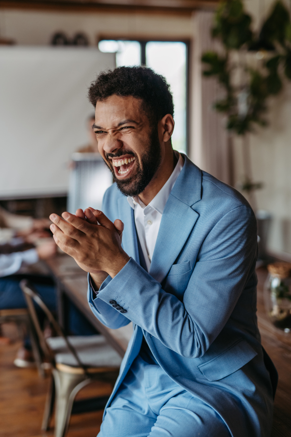 Portrait of happy, excited young businessman celebrating after closing a business deal. Business success concept.