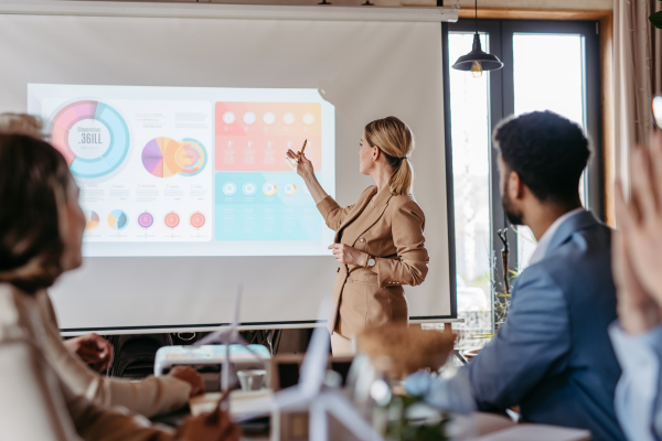 Female business leader giving a presentation about renewable energy. Young colleagues having discussion about photovoltaic panels, clean, green, energy. Business using green energy.