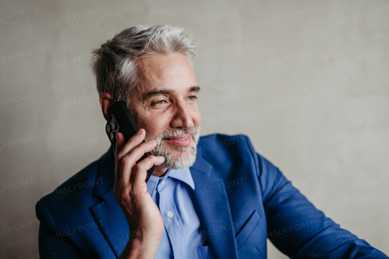 Portrait of businessman calling with his smartphone.