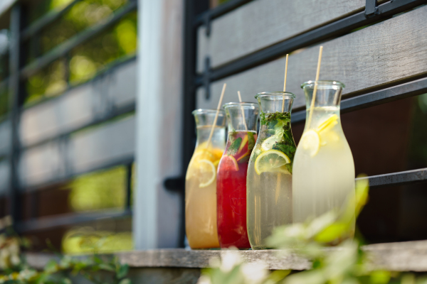 Colorful fresh fruit lemonades in glass bottles.