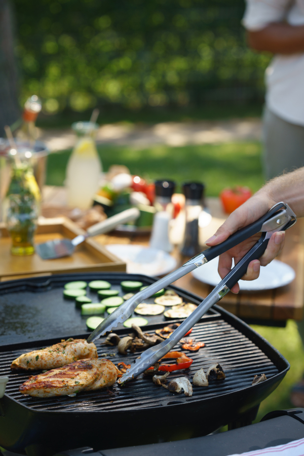 Meat and vegetables grilling on an outdoor grill. Outdoor grill or BBQ party in the garden.