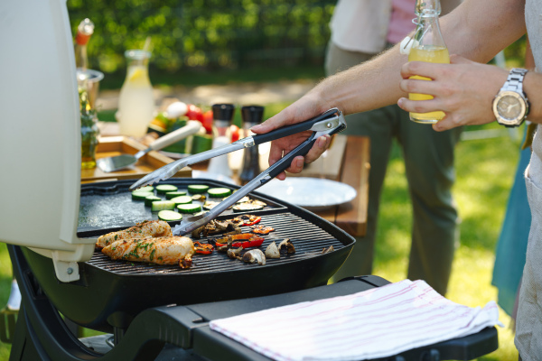 Meat and vegetables grilling on an outdoor grill. Outdoor grill or BBQ party in the garden.