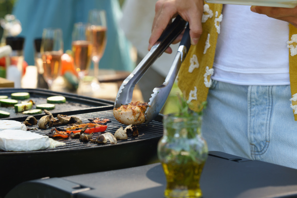 Meat and vegetables grilling on an outdoor grill. Outdoor grill or BBQ party in the garden.