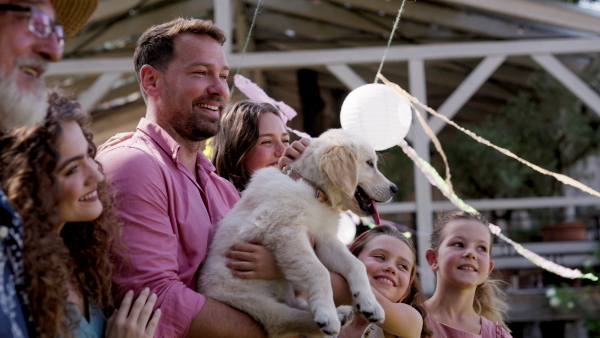 Garden birthday party with surprise. Family prepared a birthday surprise, puppy as a birthday gift.