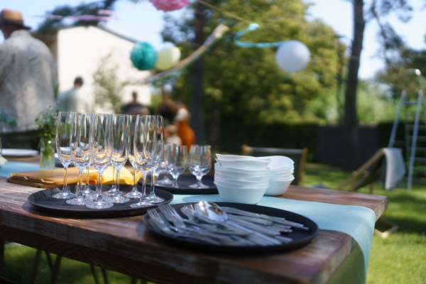 Close up shot of empty wine glasses cutlery, utensils at summer garden party.