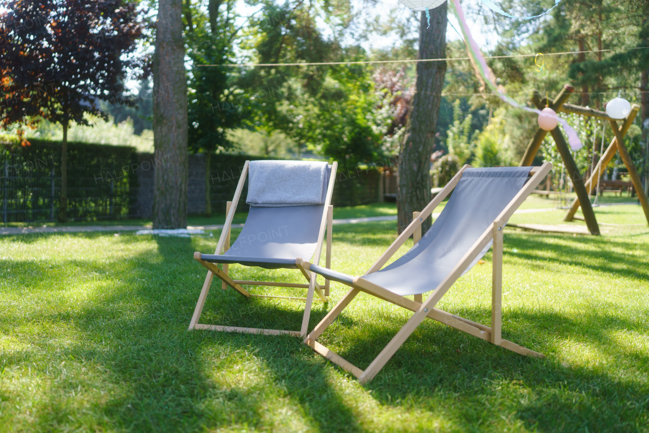 Garden loungers in garden, in the shade under the trees. Outdoor garden furniture.