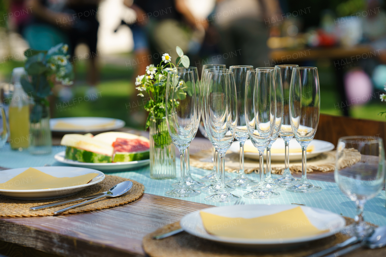 Close up shot of empty wine glasses cutlery, utensils at summer garden party.