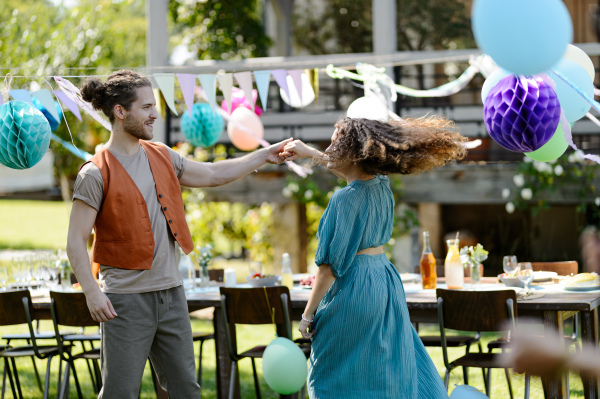 Portrait of couple in love dancing at the family garden party. A family gathering to celebrate a birthday.