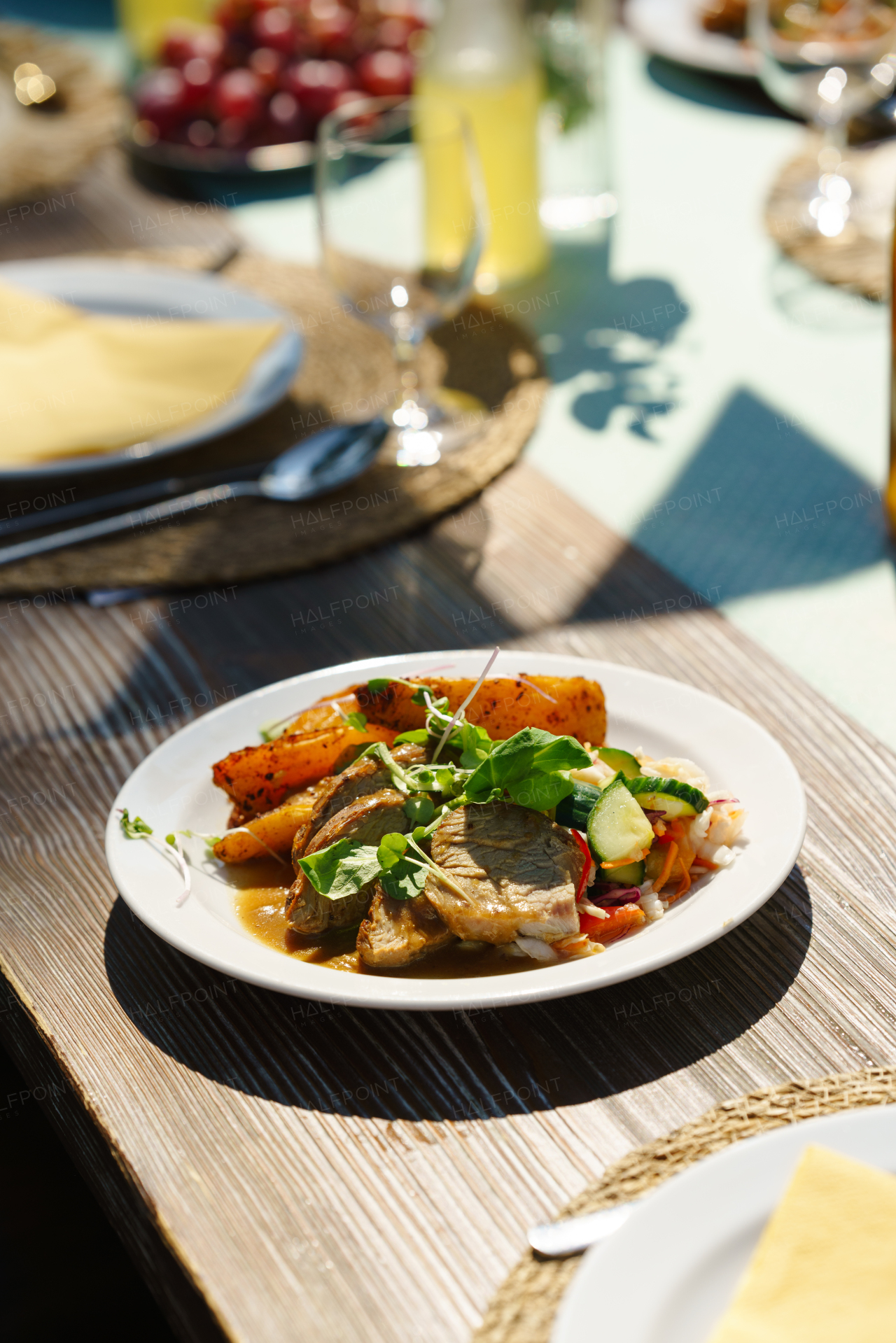 Delicious grilled food with fresh vegetable salad on a plate. Preparing meals and refreshments for a garden party. Outdoor grill or BBQ party.