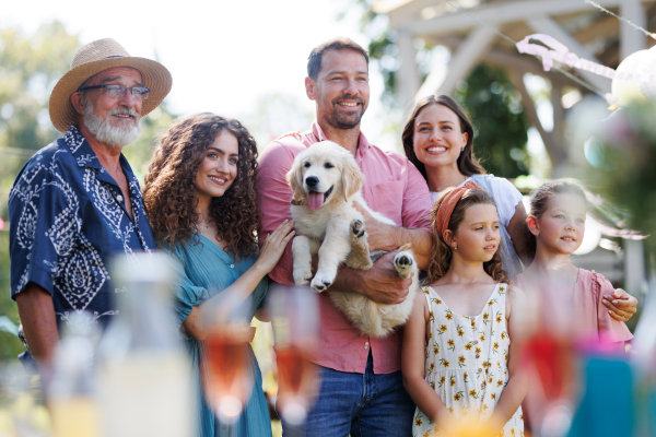 Garden birthday party for mature man. Handsome man received a puppy as a birthday gift.