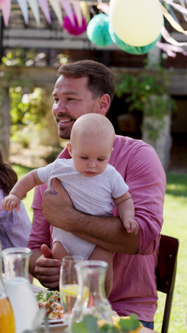 Young family with a baby at a family garden party. Father, mother, and a small child at birthday party.