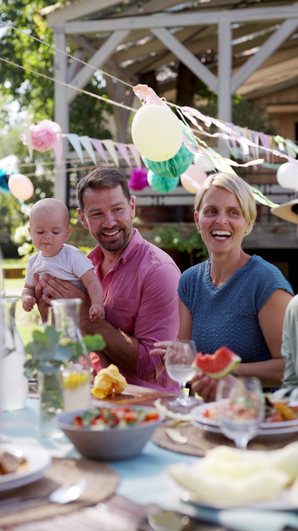 Young family with a baby at a family garden party. Father, mother, and a small child at birthday party.